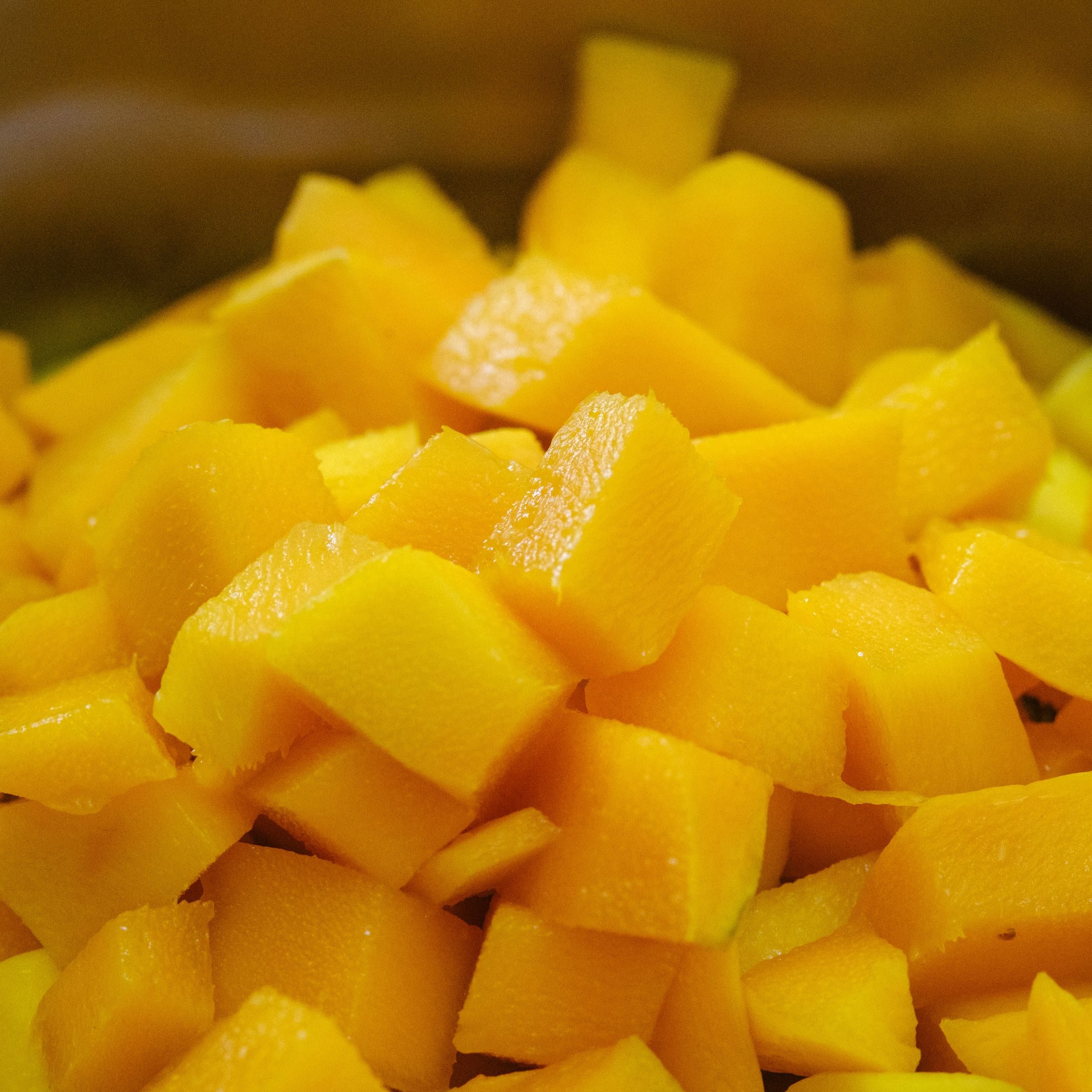 Vivid golden diced mango cubes filling the frame
